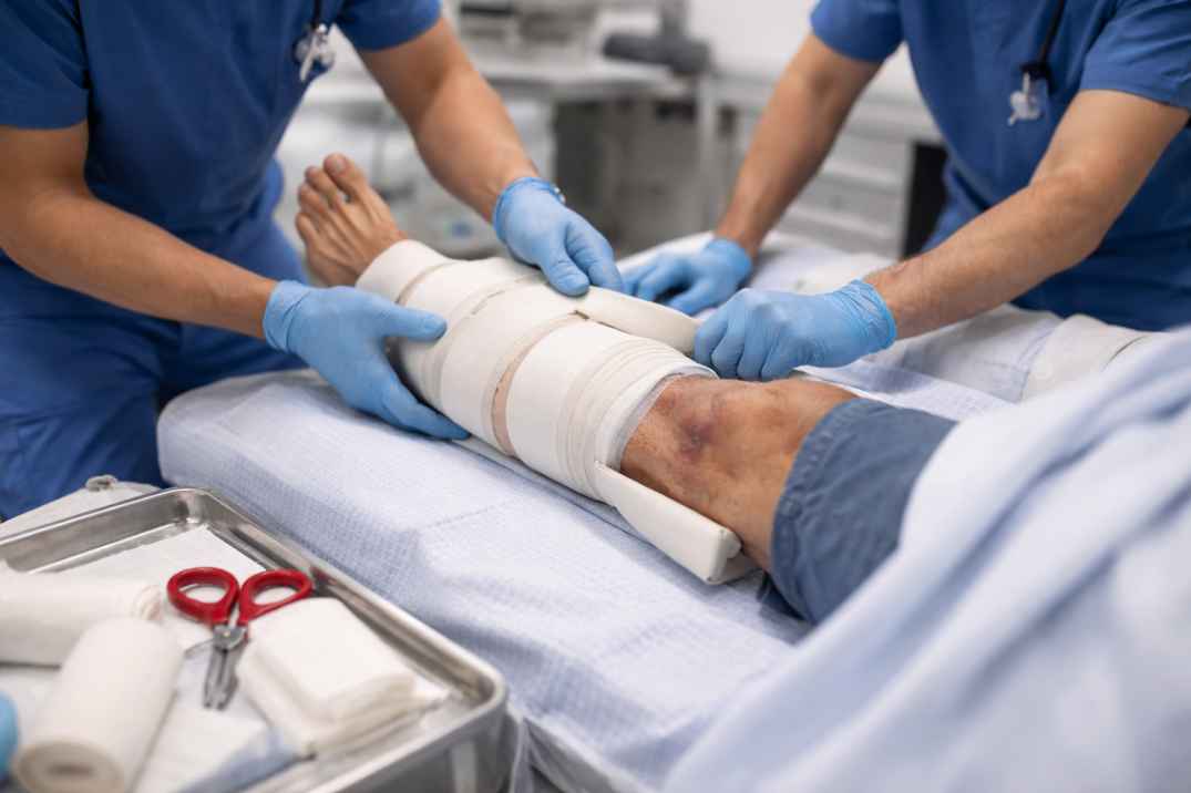 Medical staff applying a protective leg bandage after lower limb injury or surgery
