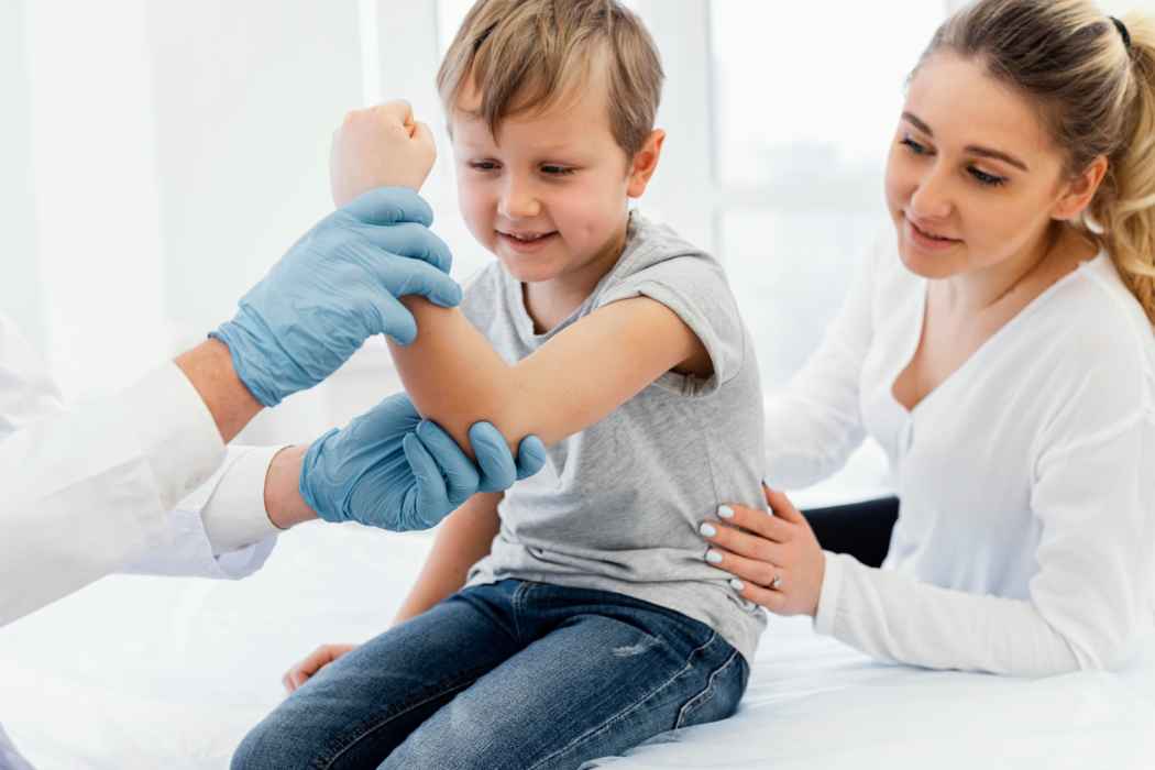 Pediatric orthopedic examination of a child’s elbow with parent present