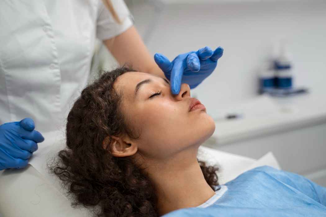 Healthcare professional examining a woman’s nose during a medical or ENT procedure