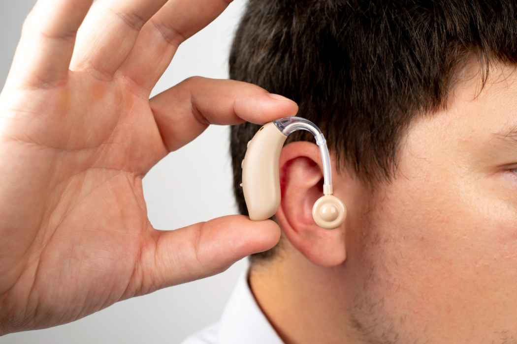 Close-up of a hearing aid placed behind the ear of a patient