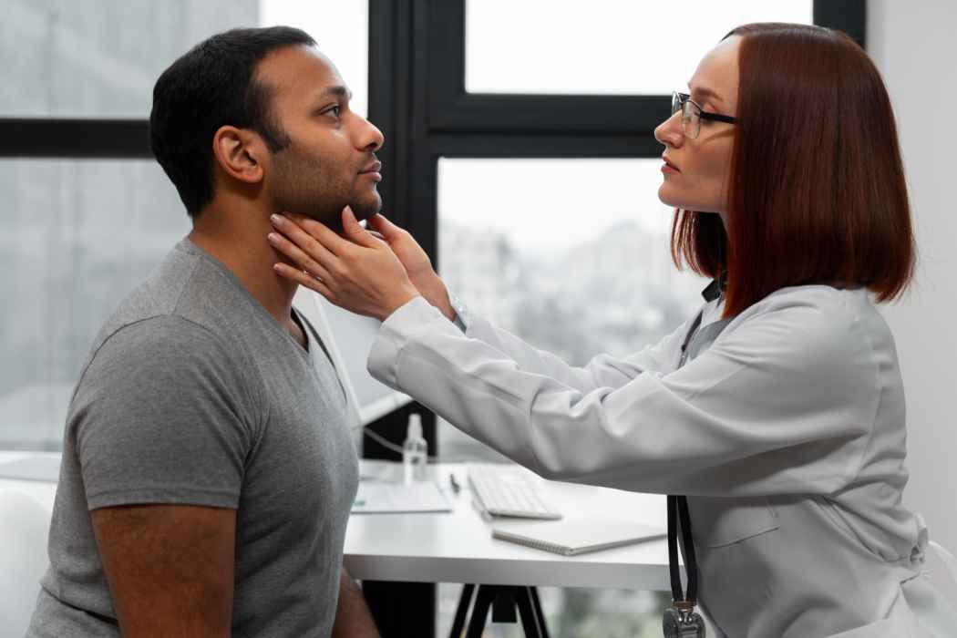 Doctor examining a male patient’s neck and throat during a medical checkup