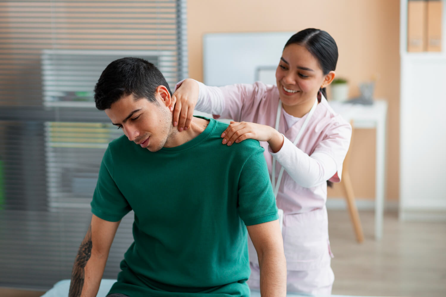 Physiotherapist performing neck and shoulder therapy for a male patient in a clinic