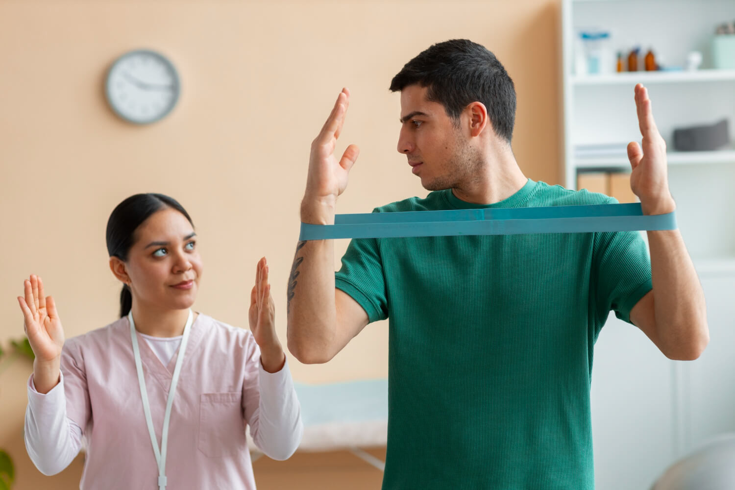 Physiotherapist guiding a patient through shoulder rehabilitation exercise using a resistance band