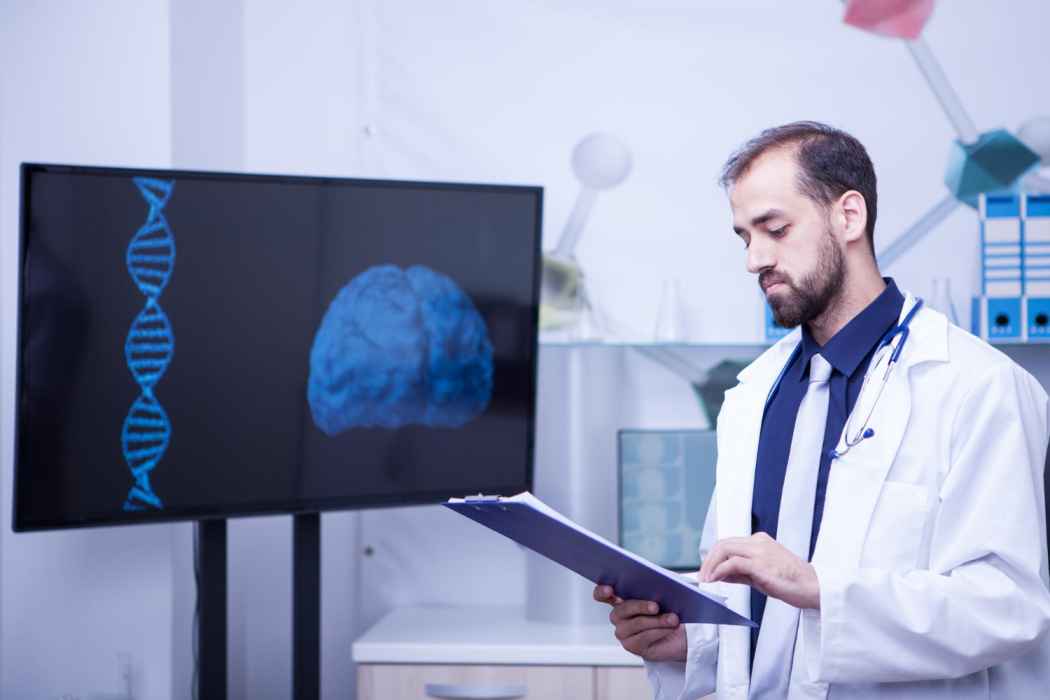 Doctor reviewing medical data with digital brain and DNA visuals on a screen