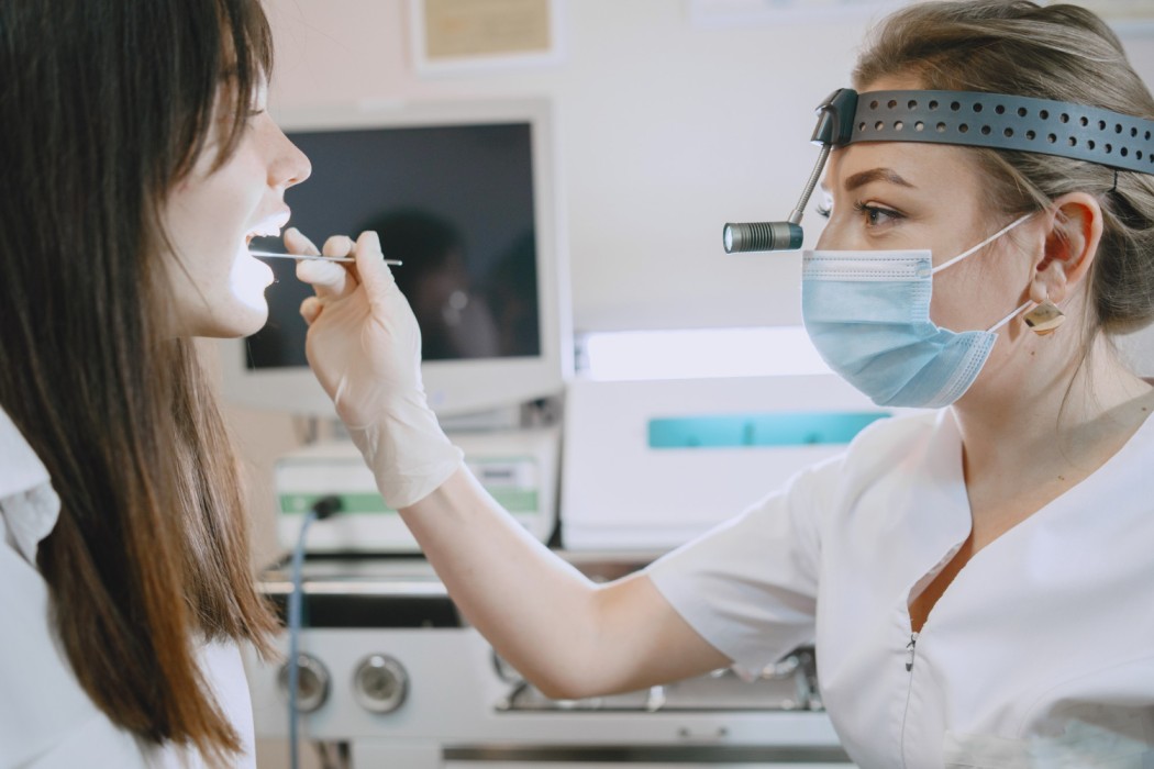 Doctor examining a patient’s throat using a medical light during a clinical checkup