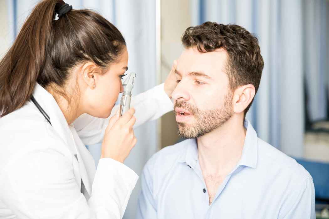 Doctor performing an eye examination using an ophthalmoscope
