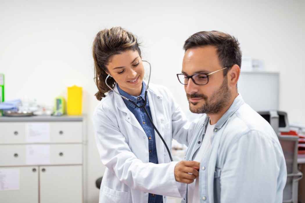 Doctor checking a patient’s chest using a stethoscope during a medical examination