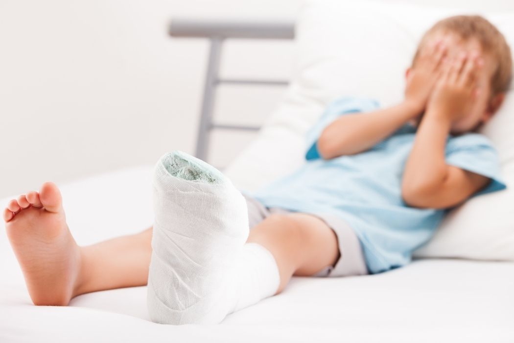 Child resting with leg cast after fracture treatment in hospital