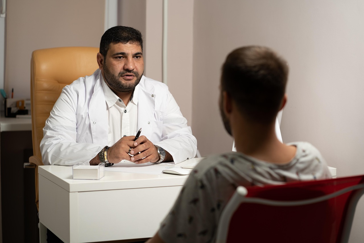 Doctor consulting with a male patient during a private medical appointment in a clinic.