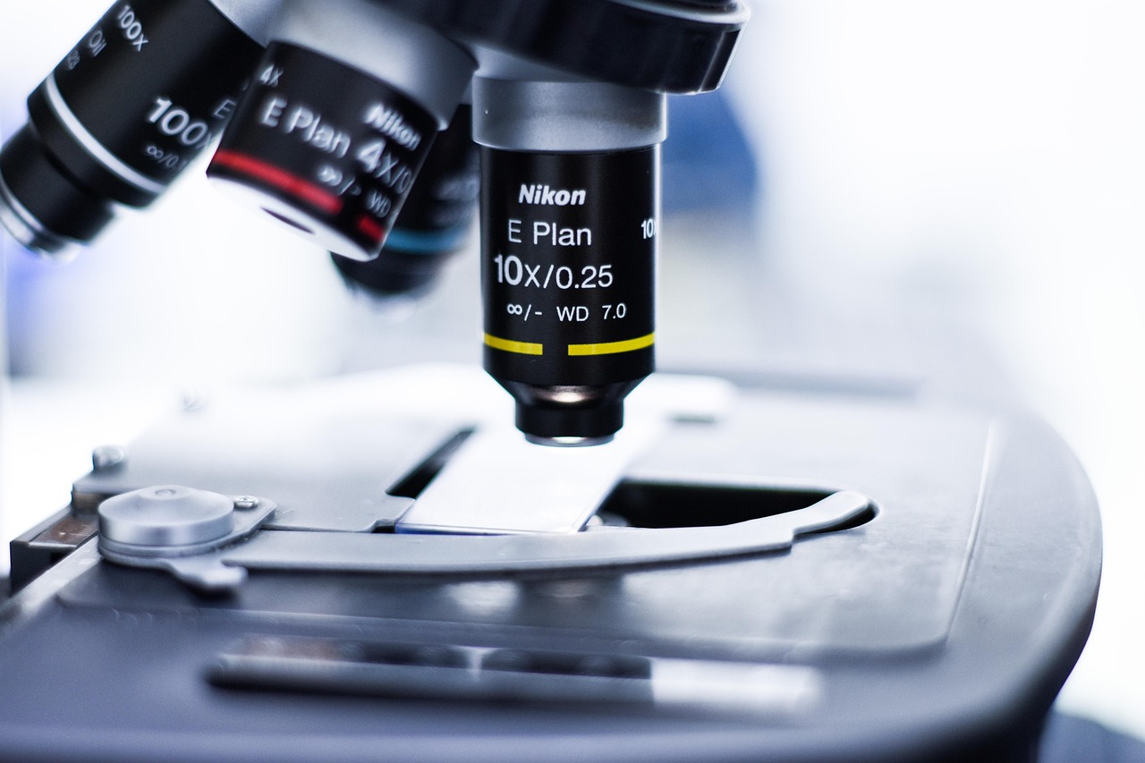 Close-up of a laboratory microscope examining a glass slide during scientific analysis.