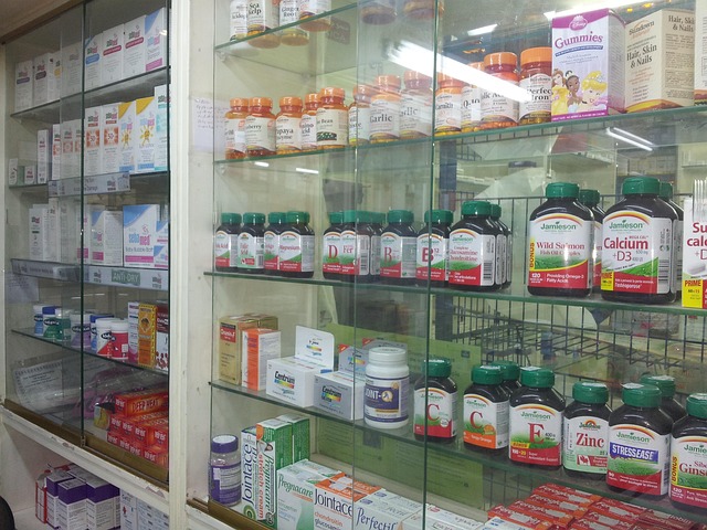 Pharmacy display shelves stocked with vitamins, supplements, and over-the-counter medicines.