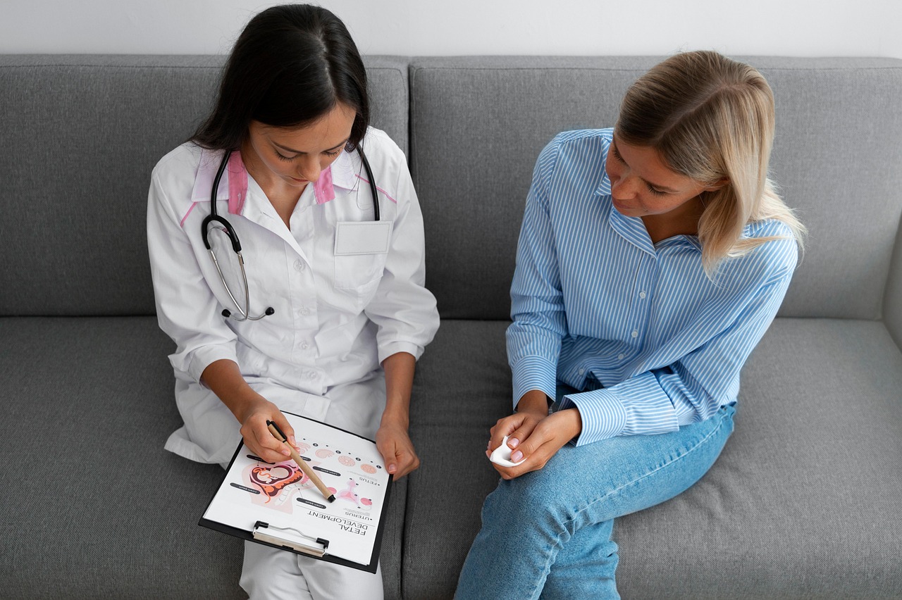 Doctor explaining digestive health information to a female patient during a medical consultation.