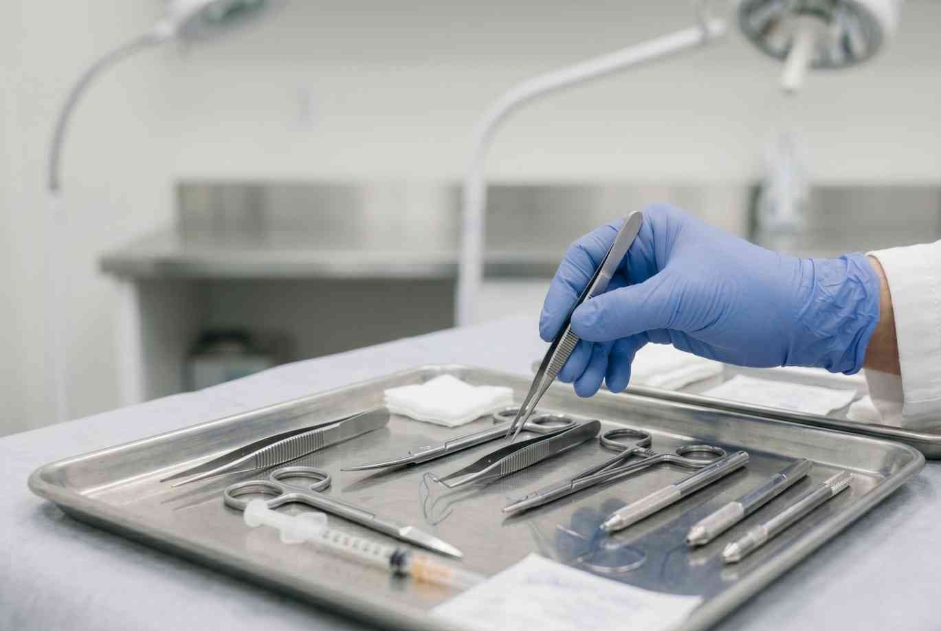 A doctor picking up surgery equipment