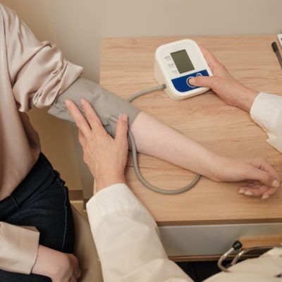 A doctor taking BP of a patient