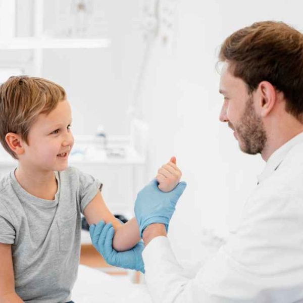 Doctor examining a child’s arm during a pediatric orthopedic consultation