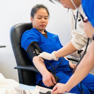 A doctor taking BP of a patient