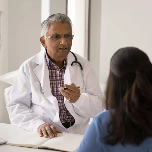 Senior doctor talking with patient during medical consultation in hospital